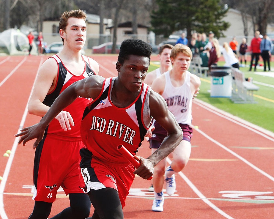 Red River George Nyanforh takes off after the baton pass from Riley Benson at Tuesday afternoons track meet in at Cushman Field in Grand Forks. Jesse Trelstad/ Grand Forks Herald